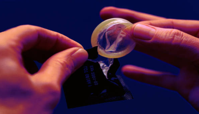 Person holding condom for safe sex.